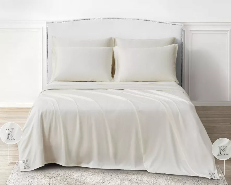 Ivory sheet set on king-size bed with two pillows and flat top sheet