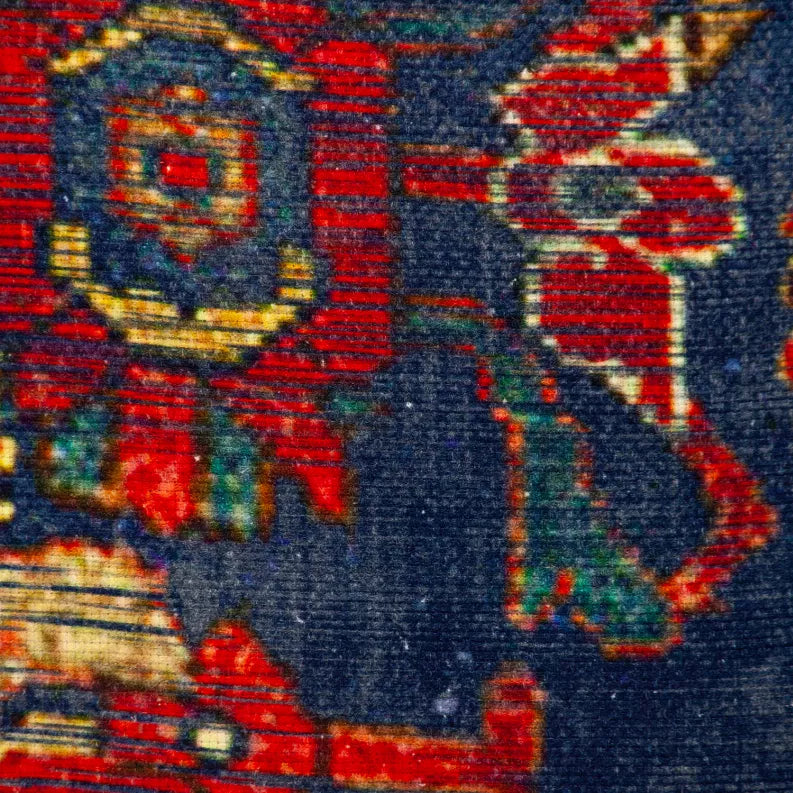 Close-up of navy blue tapestry pillow with red and gold embroidered motifs