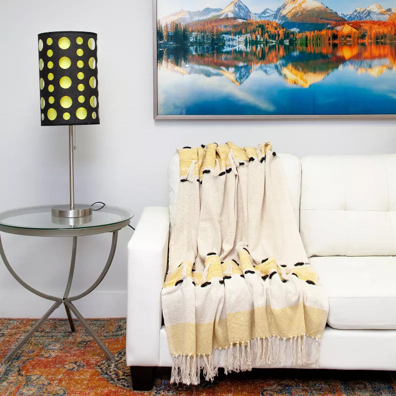Cream throw blanket with yellow stripe band, black paw prints, and long fringe
