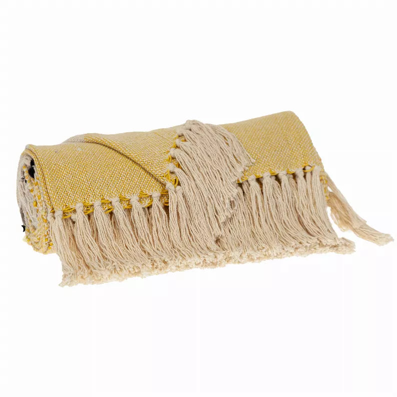 Folded yellow and cream throw blanket with black paw prints and white fringe
