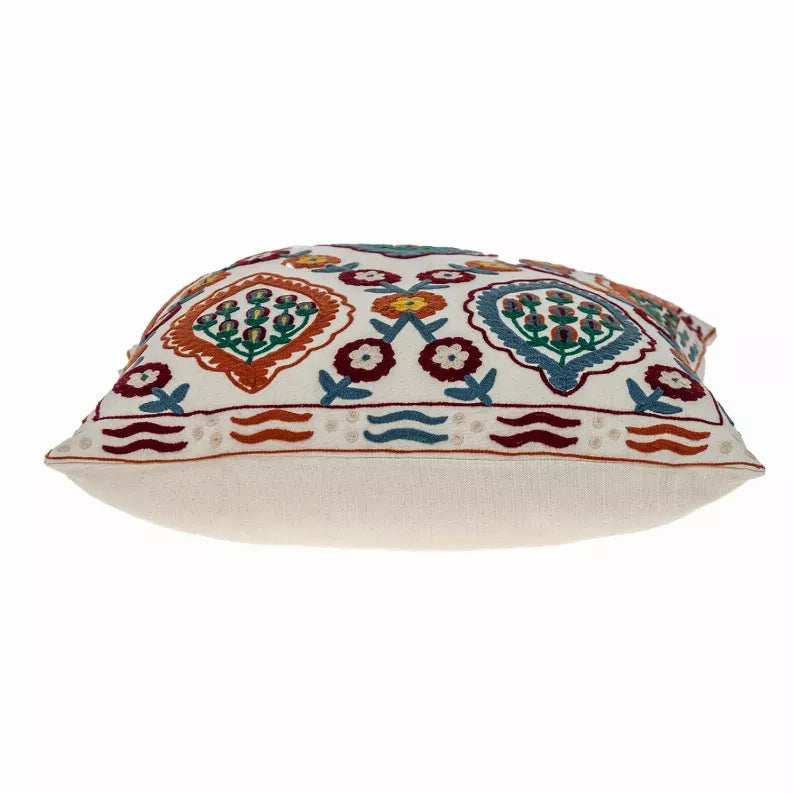 Multicolor embroidered throw pillow side view with cream backing and patterned top