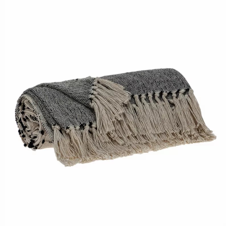 Woven handloom throw rolled up, geometric stripes in beige and dark gray, tassel fringe