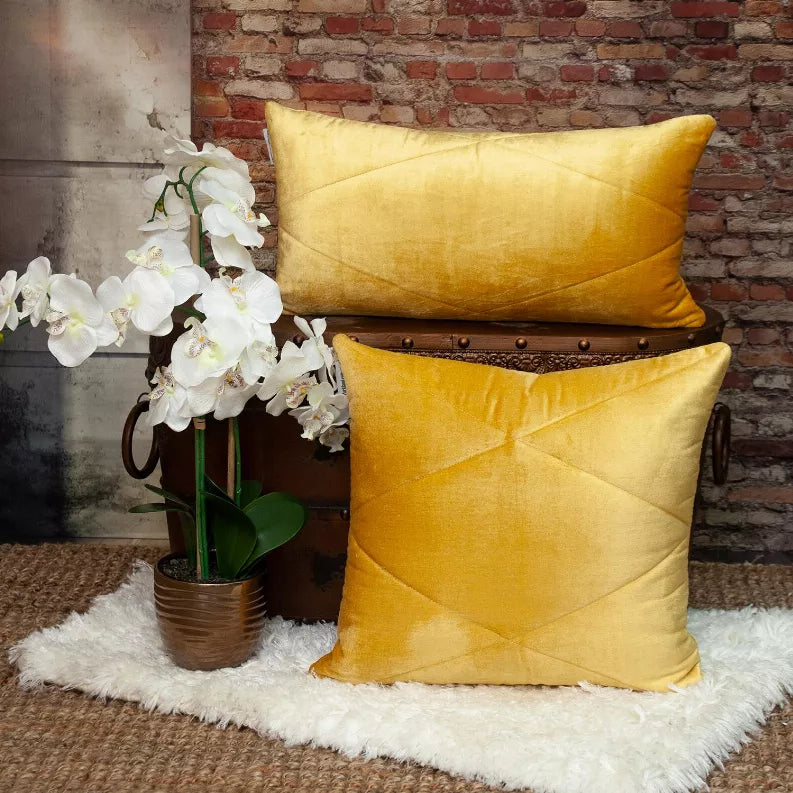 Set of yellow quilted throw pillows stacked, both with diamond seam detail