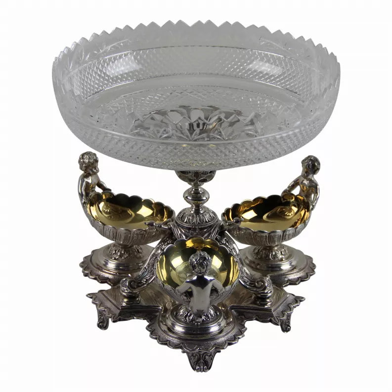 Ornate silver-plated epergne with faceted glass center and cherub basins