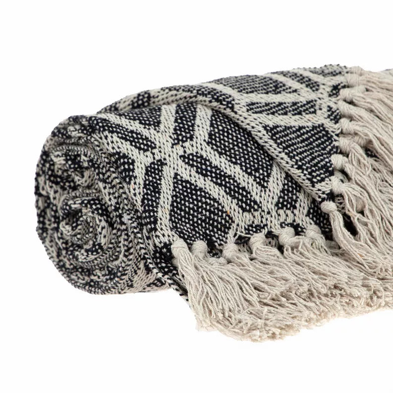 Woven throw blanket rolled up, diamond lattice pattern in dark gray and light beige, fringe