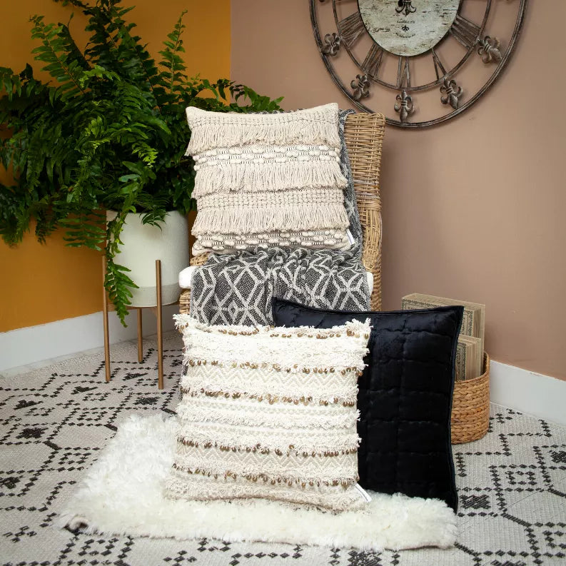 Folded woven throw blanket with geometric pattern, dark gray and light beige, fringe trim