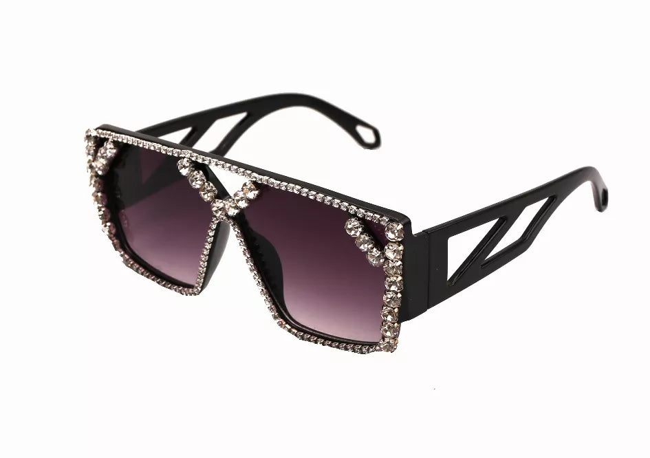 Black sunglasses with purple lenses and rhinestone-trimmed angular frames