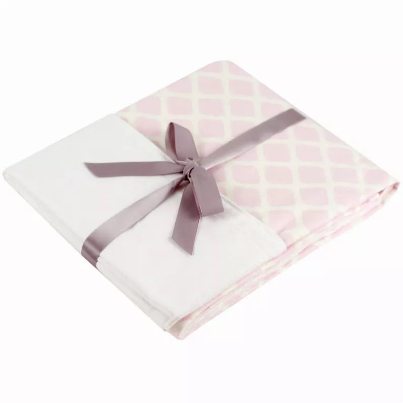 Reversible crib blanket sheet with pink lattice, folded and tied with gray ribbon