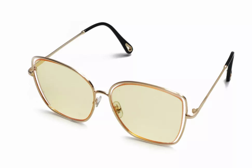 Sunglasses with pale yellow tinted lenses, gold metal frame, black temples.