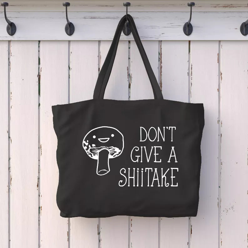 Black tote bag with white 'DON'T GIVE A SHIITAKE' text and mushroom graphic