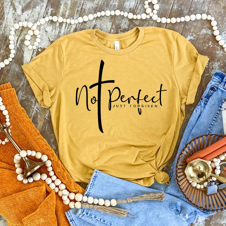 Mustard short-sleeve T-shirt with black "Not Perfect Just Forgiven" graphic.
