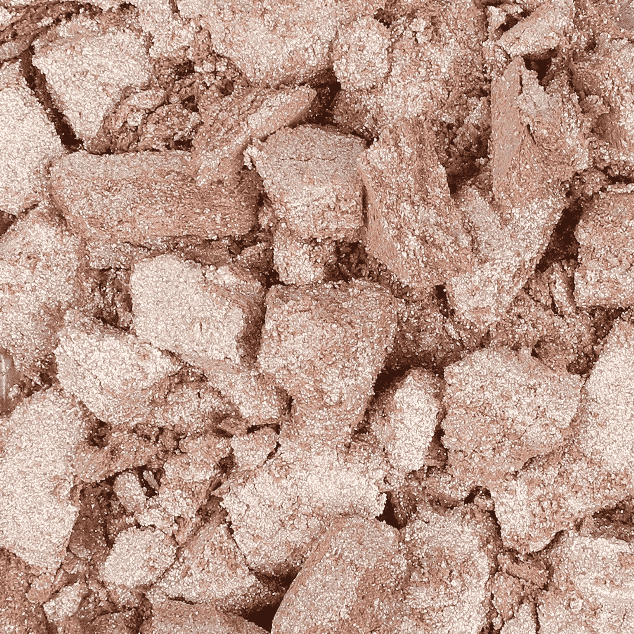 Shimmery rose-gold highlighter swatch with glittery powder texture