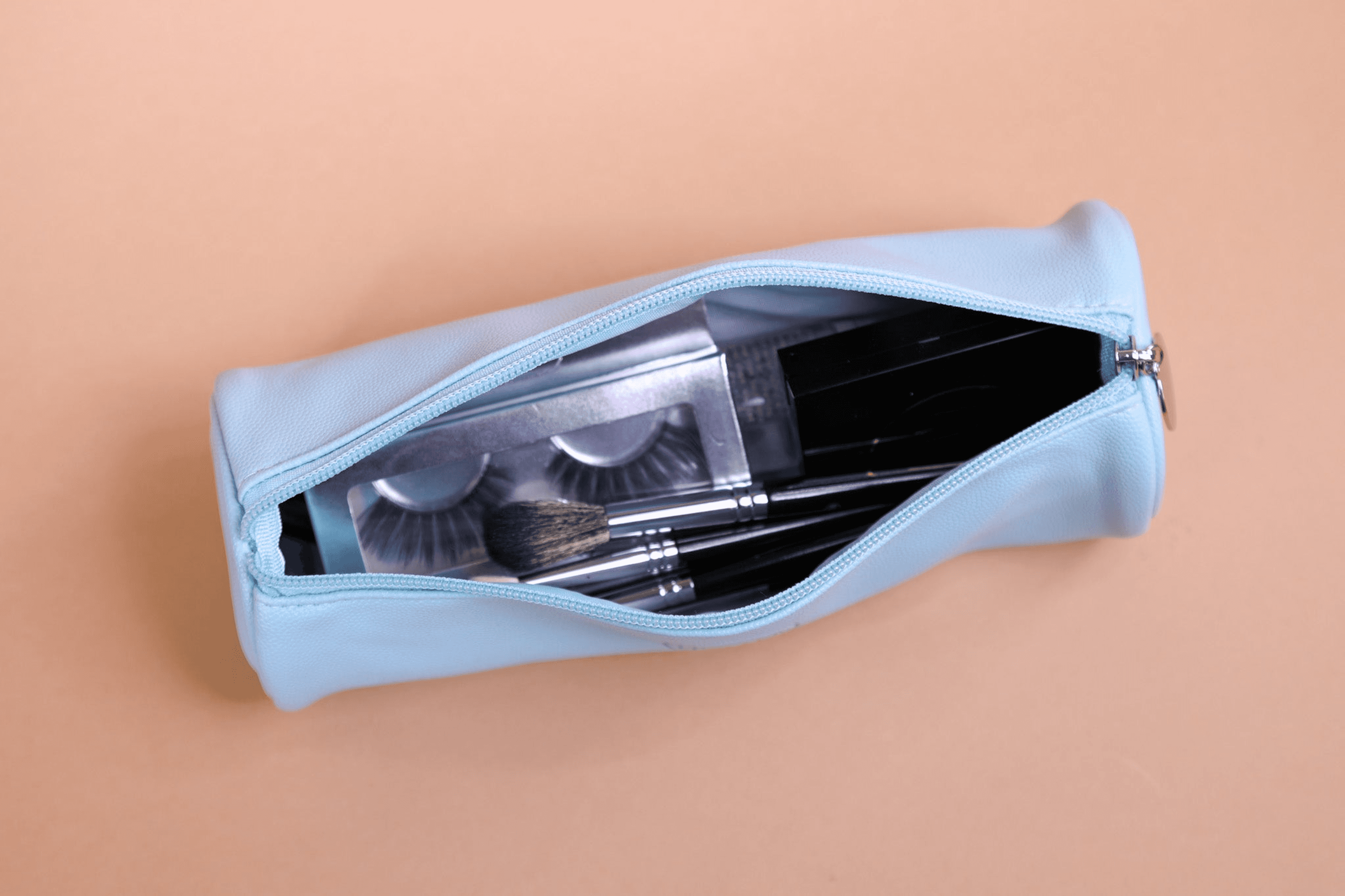 Light blue open brush bag showing rows of makeup brushes inside