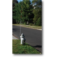 Fiberglass fire hydrant marker stake with reflective top, mounted at curbside on grass