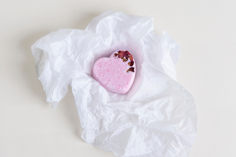 Pink heart-shaped shower steamer on white crinkle paper