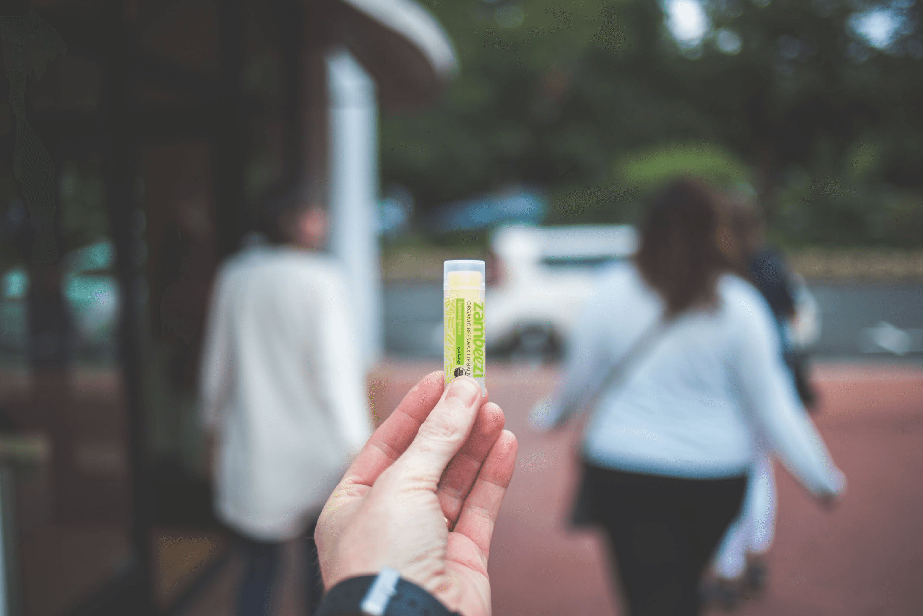 Hand holding a Zambezi lemongrass organic beeswax lip balm stick