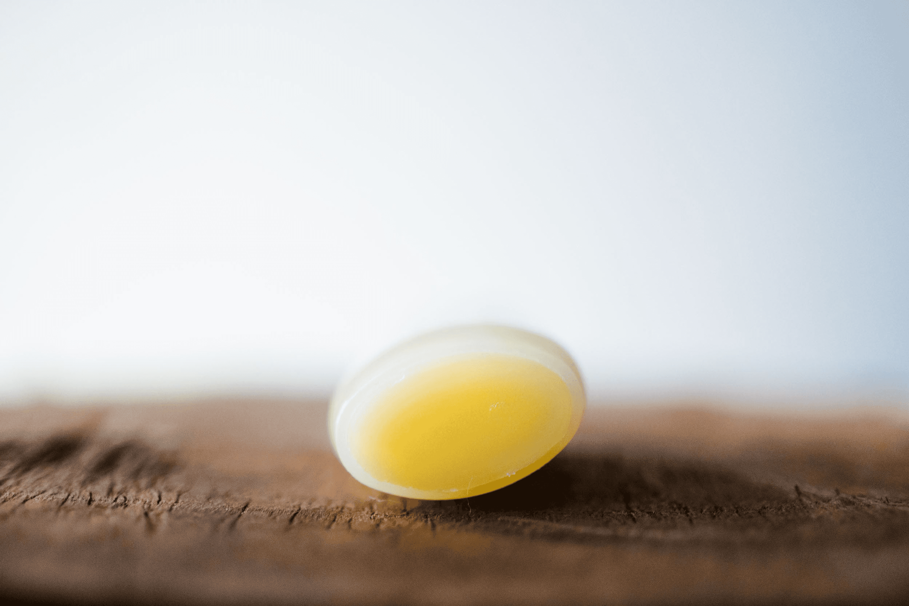 Round yellow lemongrass organic beeswax lip balm cap-side close-up