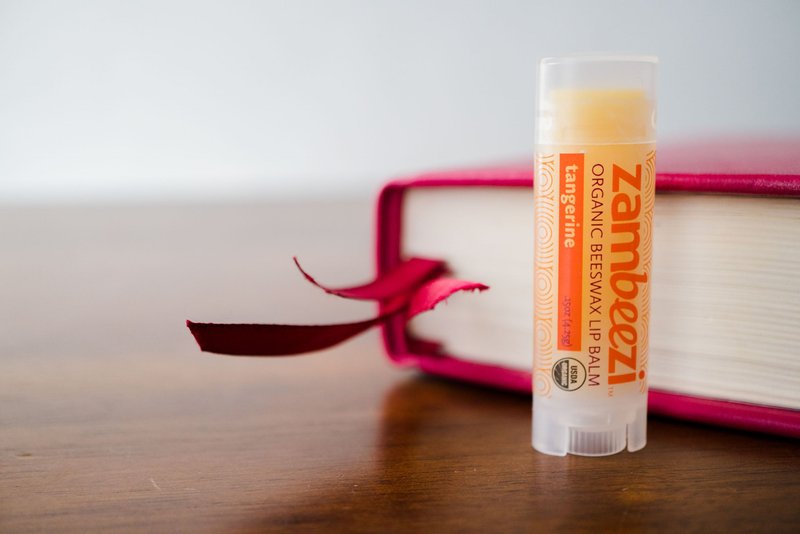 Tangerine organic beeswax lip balm tube on its case holder