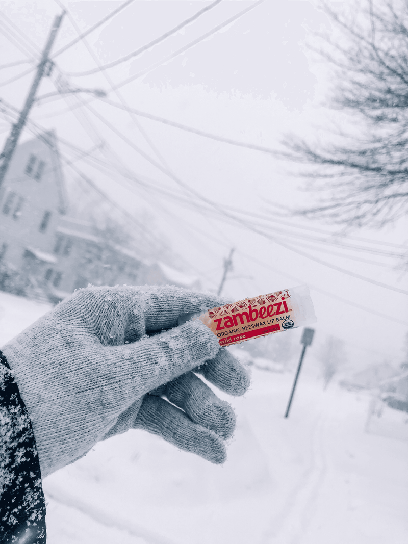 Zambezi lip balm stick held in a winter glove, on snow
