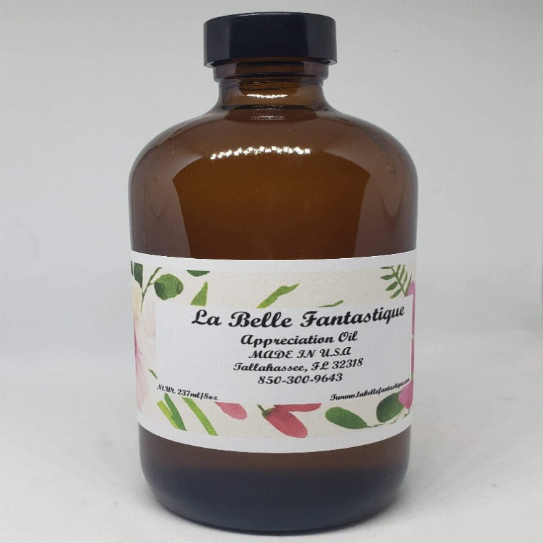 Amber body oil bottle with black cap and floral label, 8 oz