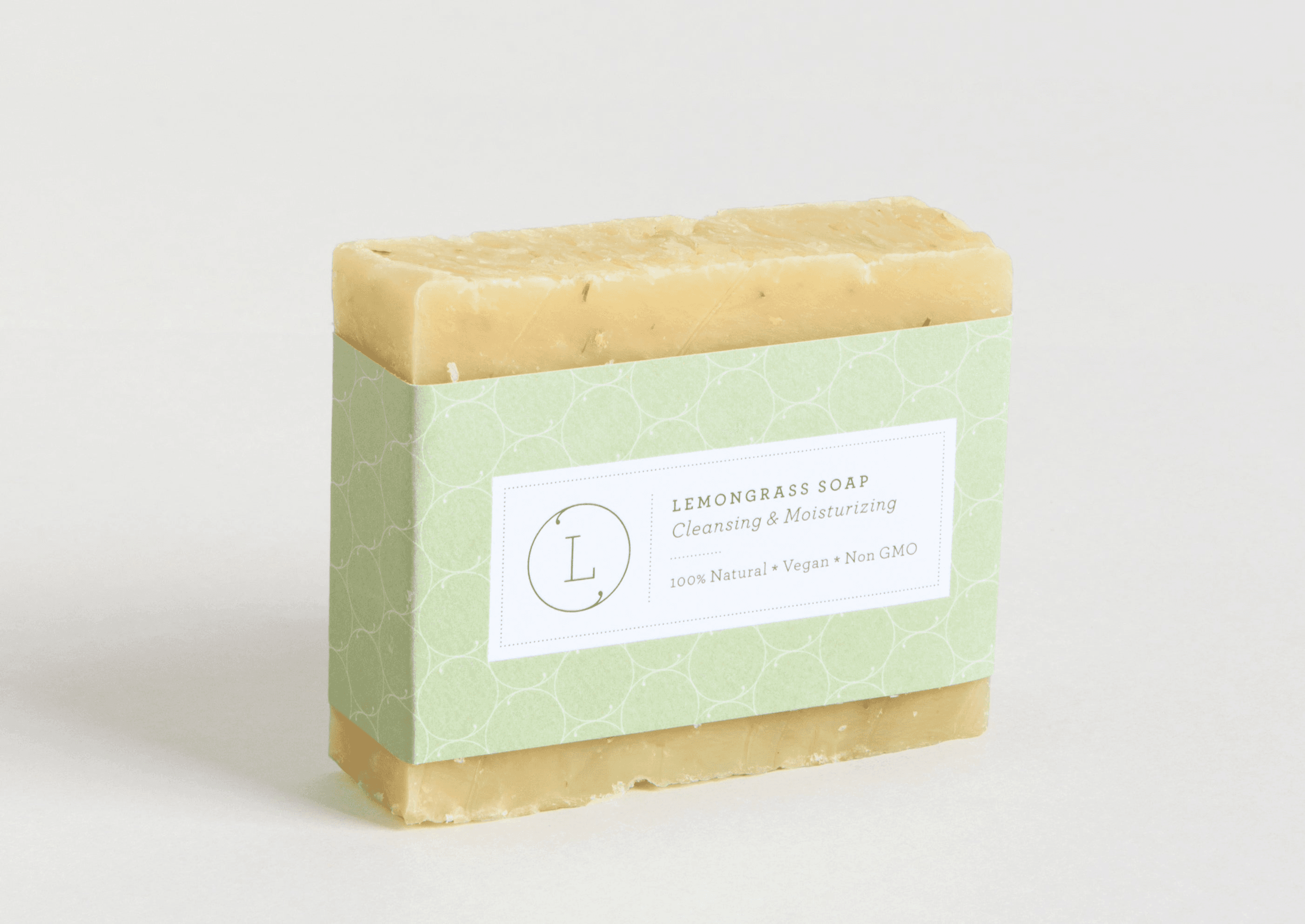 Handmade lemongrass soap bar with green wrap and white label, rectangular block
