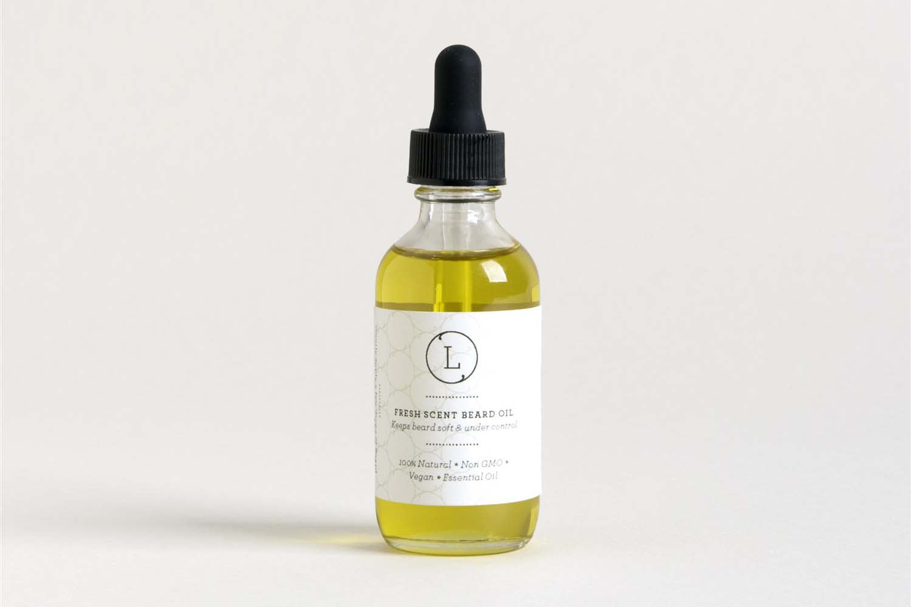 Amber massage oil in clear glass bottle with black dropper, white label