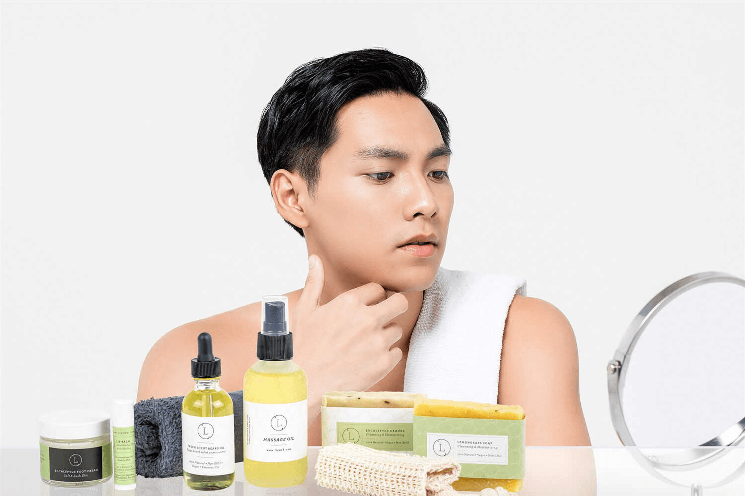 Person holding skincare products tray with soap bars and oil bottles by mirror