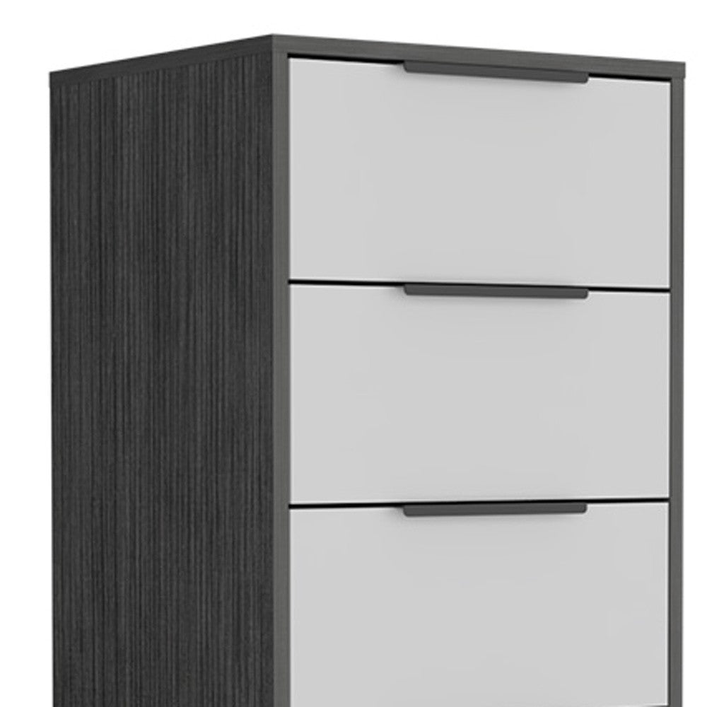 Close-up of dark gray side panel and white drawer fronts with black pulls
