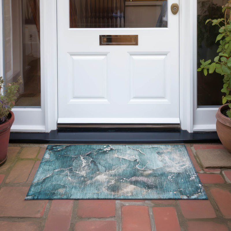 Teal abstract area rug on patio tiles, distressed beige swirls and speckled texture