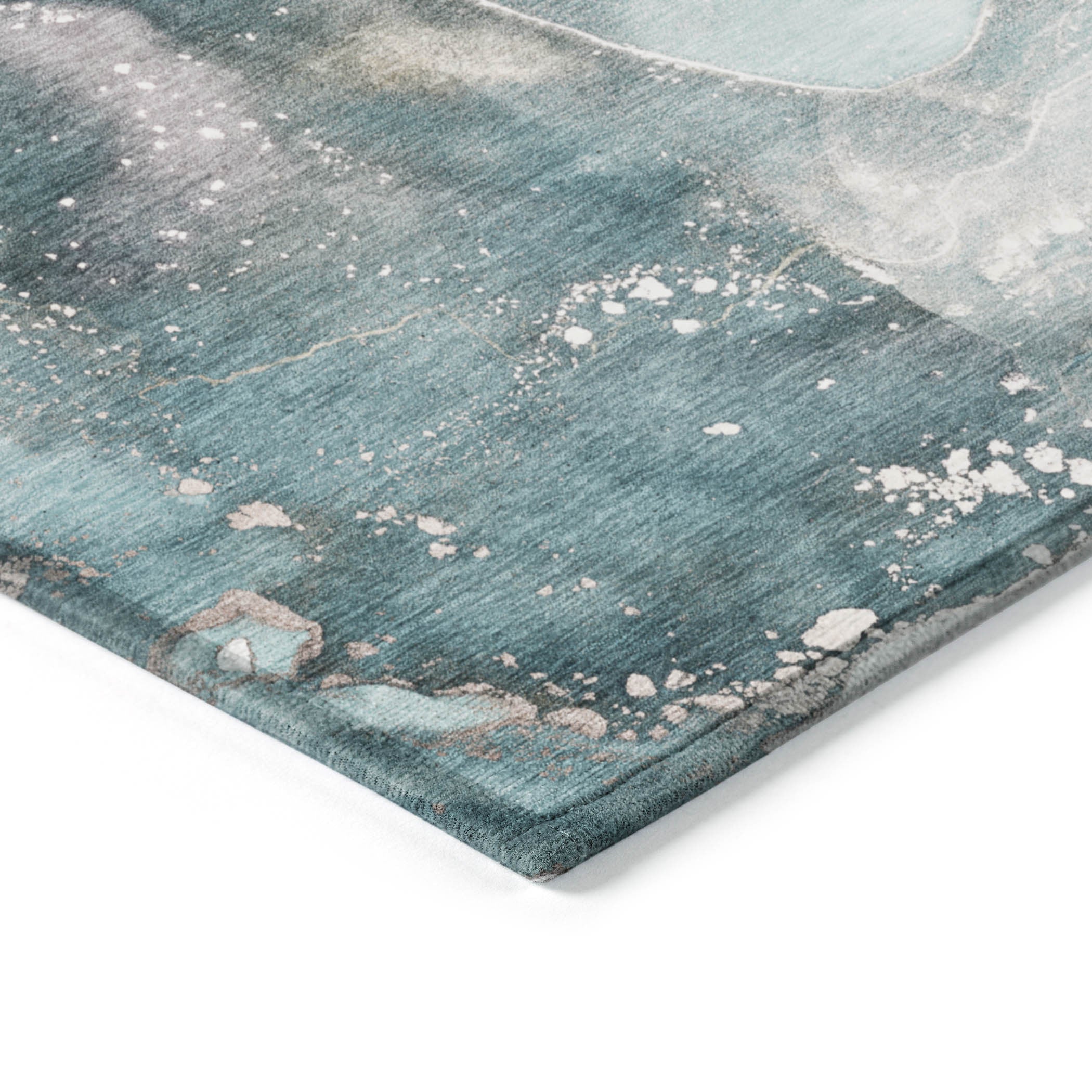 Teal abstract area rug corner detail with white speckles on textured surface