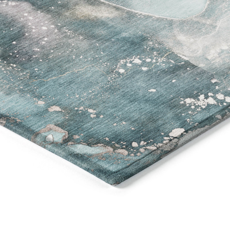 Teal abstract area rug corner detail with white speckles on textured surface