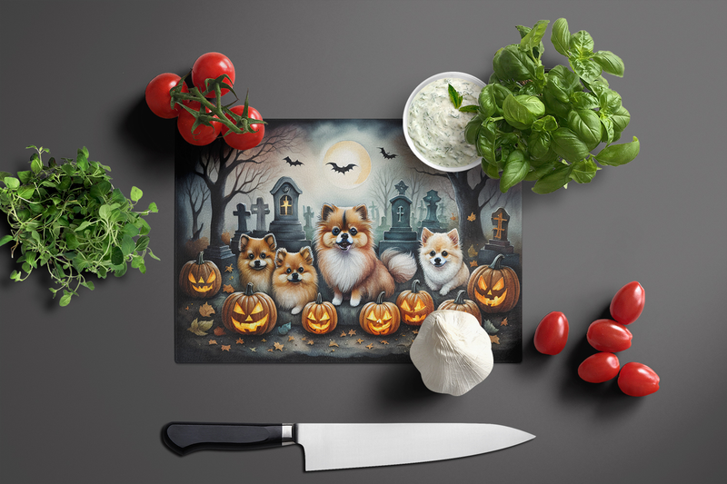 Glass cutting board with Pomeranian pups, jack-o'-lanterns, and tombstones