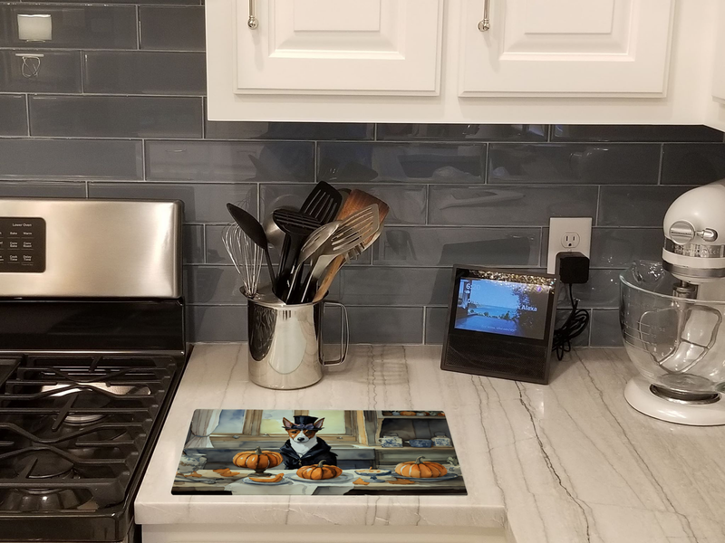 Glass cutting board on counter with Basenji dog and pumpkin fall scene
