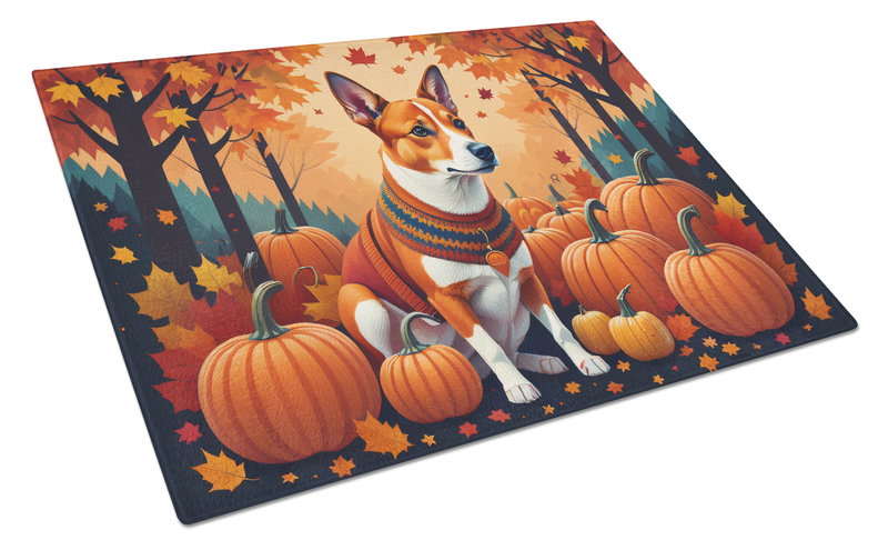 Glass cutting board featuring basenji dog among pumpkins and autumn leaves