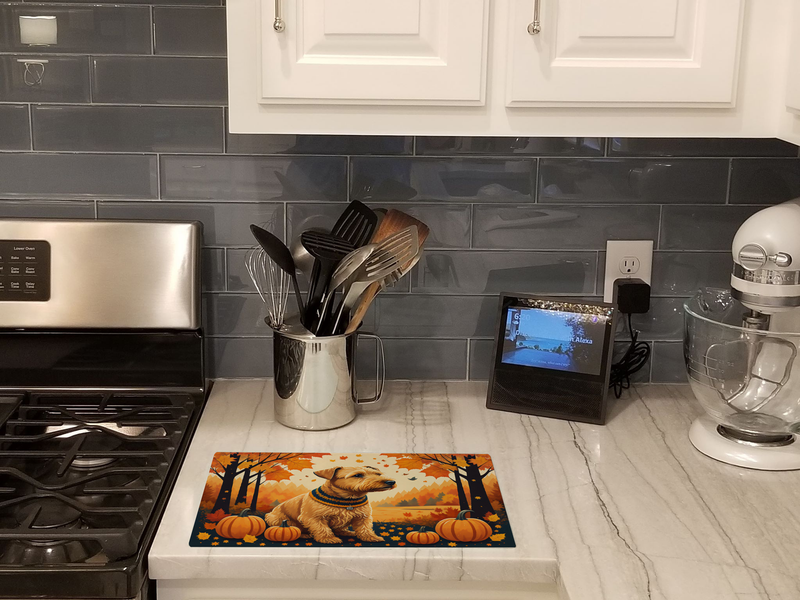 Glass cutting board on kitchen counter, terrier autumn pumpkins printed on top
