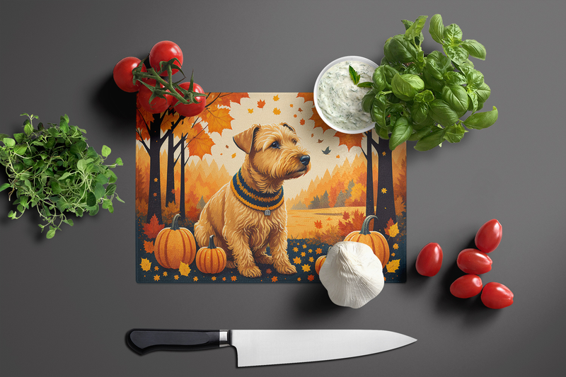 Glass cutting board with terrier autumn design, with knife and vegetables around it