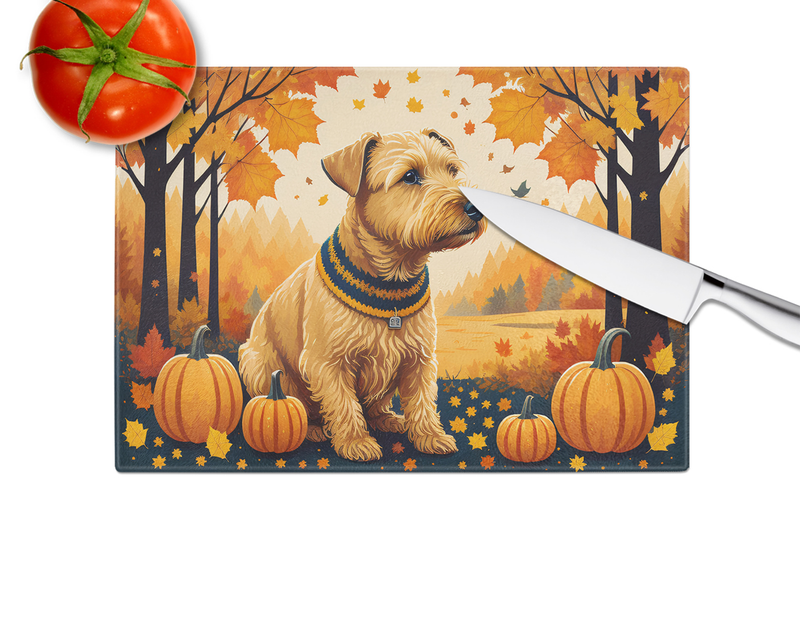 Glass cutting board with terrier autumn artwork and pumpkins, white knife along side