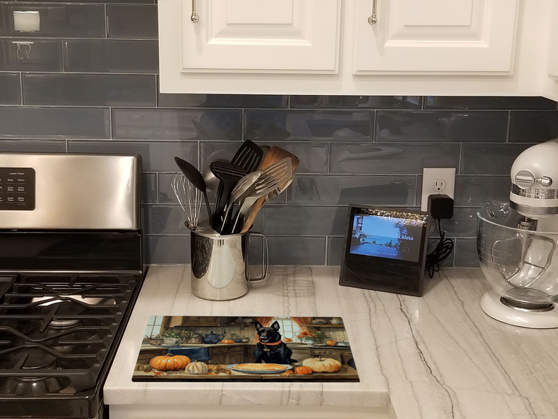 Rectangular glass cutting board shown on countertop with fall pumpkins and Malinois
