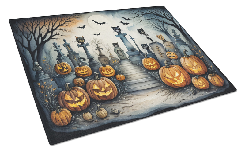 Halloween glass cutting board with cat silhouettes, tombstones, and carved pumpkins