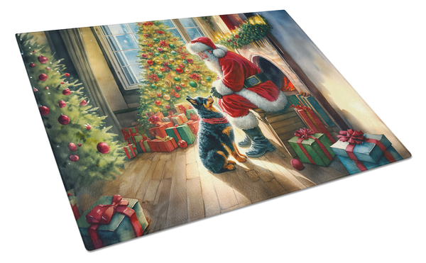 Glass cutting board featuring Santa with gifts and a cat by a lit Christmas tree