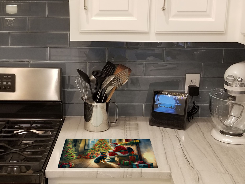 Glass cutting board with Santa and gift scene, standing on kitchen countertop