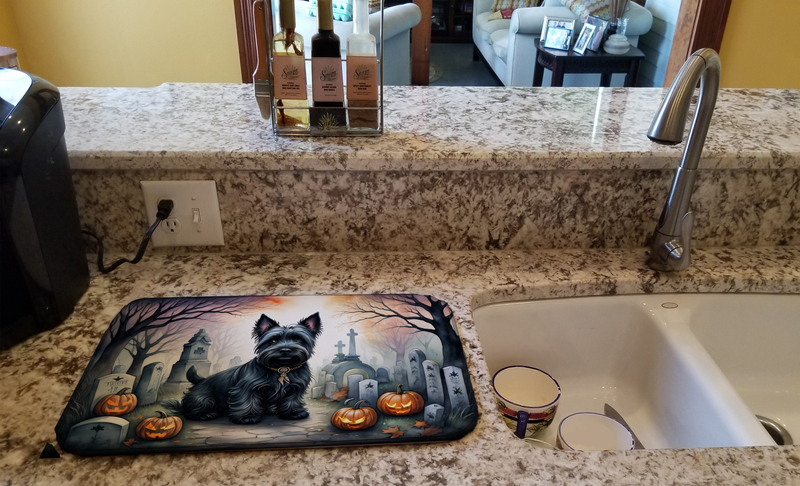 Halloween dish drying mat featuring black terrier with pumpkins and tombstones by sink