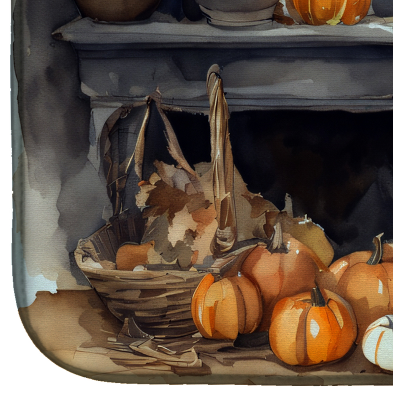 Close-up fall dish drying mat corner with pumpkins, leaves, and basket illustration