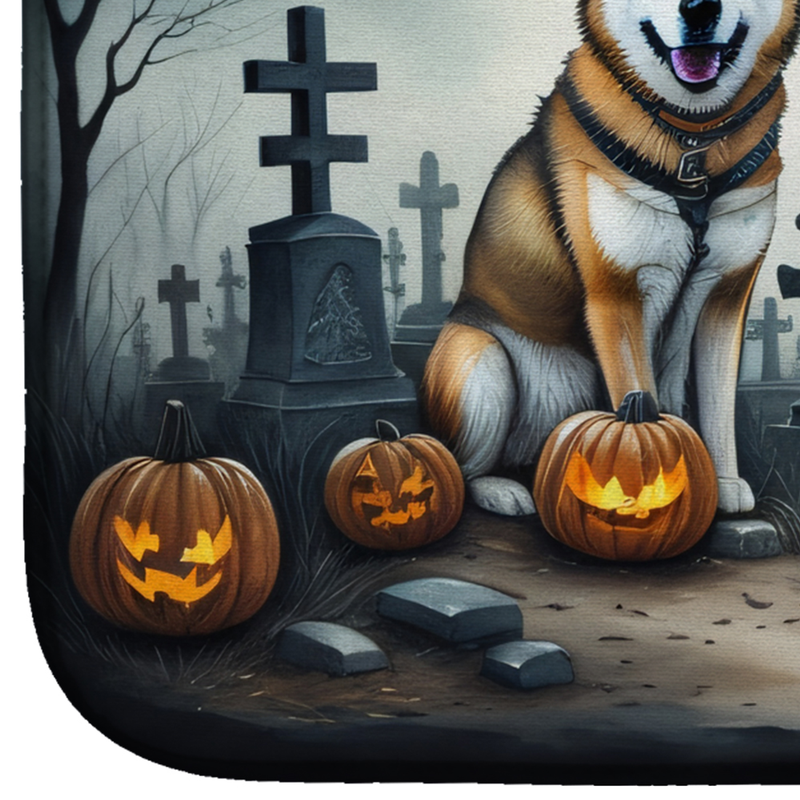 Halloween dish drying mat close-up with an Akita, pumpkins, and graveyard tombstones