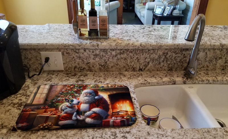 Dish drying mat with Santa and bull terrier design placed beside a kitchen sink
