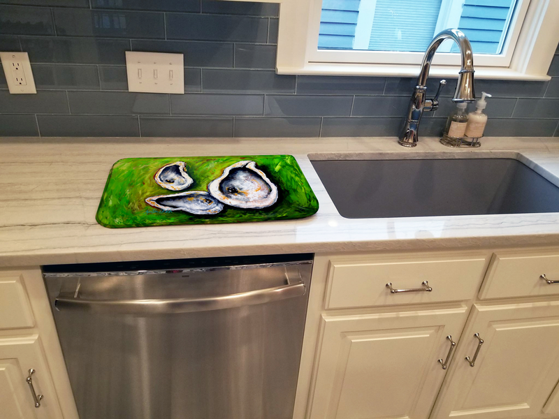 Dish drying mat with green oyster print placed beside kitchen sink
