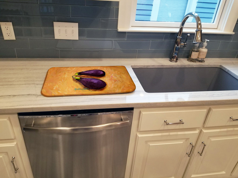 Orange dish drying mat with eggplant print beside sink