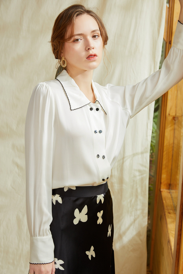 Ivory silk button-up shirt with contrast point collar, long sleeves, and dark buttons