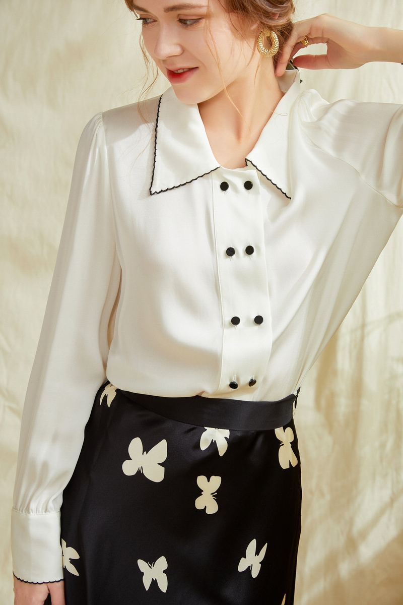 Ivory silk button-up shirt close-up: contrast point collar and dark button front