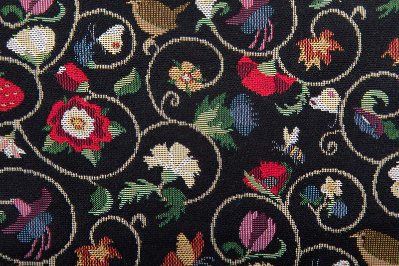 Close-up of black patterned fabric with multicolor floral and swirl motifs